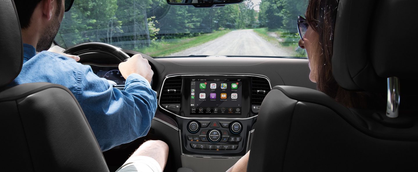 The interior of the 2021 Jeep Grand Cherokee with a driver and passenger in the front seats.