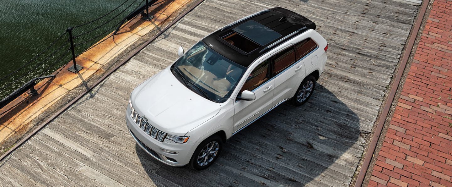 The 2021 Jeep Grand Cherokee Summit parked on a boardwalk by the water.